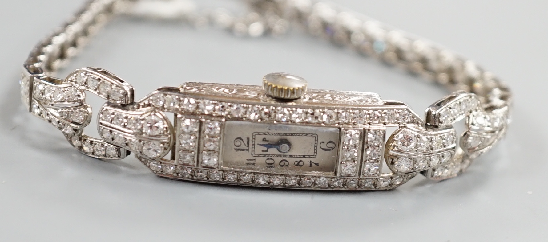 A lady's white metal and diamond set rectangular dial manual wind cocktail watch, with diamond set bracelet, cased diameter 11mm, gross weight 20.5 grams, with two spare links.